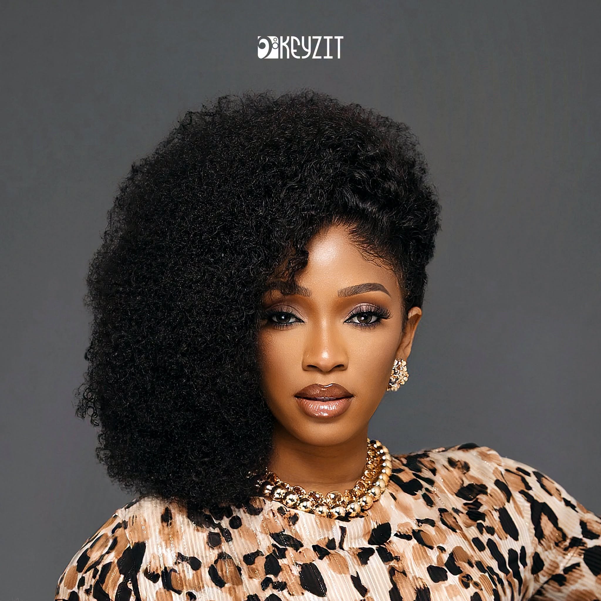 Portrait officiel de Djelykaba Bintou — coiffure afro, tenue léopard et bijoux dorés